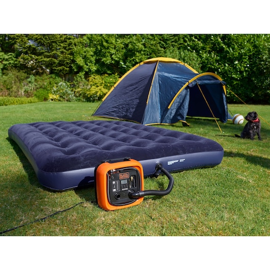 BLACKDECKER ASI400 air inflator pumping a blue air mattress outdoors near a tent on grass.