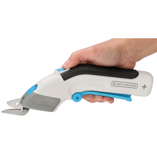 BLACK+DECKER BCSC115 white and blue cordless electric scissor handheld, side view in hand, on white background.