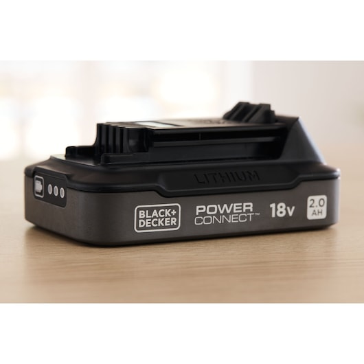 BLACK+DECKER lithium battery BDL2018S, 18V 2.0AH, side angle, on light wood surface.
