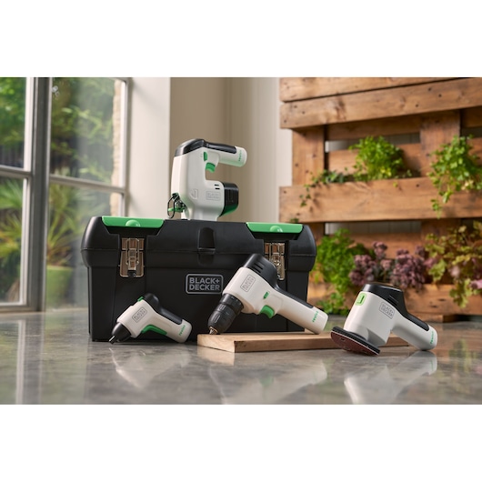 BLACK+DECKER BDST60120 tool set with white and green power tools on toolbox, indoor setting.