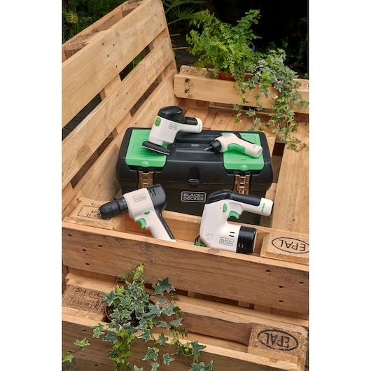 BLACKDECKER BDST60120 power tool set with four white and black tools, green accents, and black toolbox on wooden pallet.