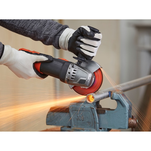 BLACKDECKER BEG210K angle grinder, close-up, cutting metal pipe with sparks flying, photography