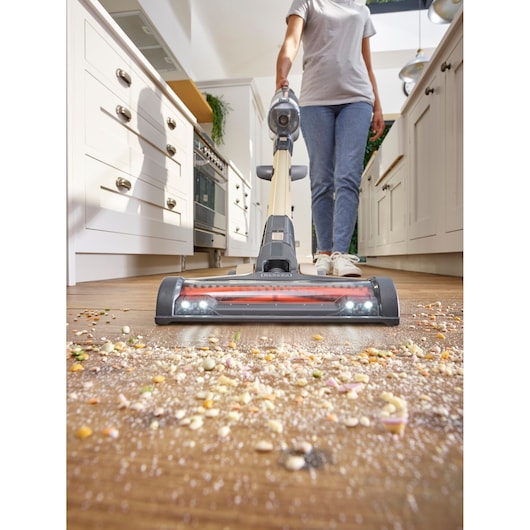 BLACKDECKER BHFEV36B2D cordless stick vacuum in kitchen cleaning scattered debris, front angle