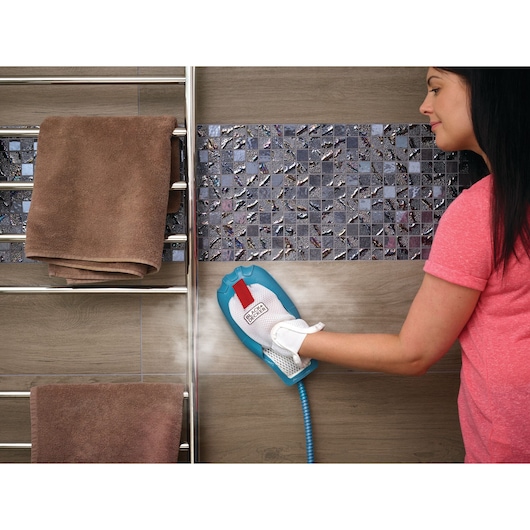 BLACKDECKER BHSM1610DSM steam cleaning glove cleaning bathroom wall tiles next to towel rack.