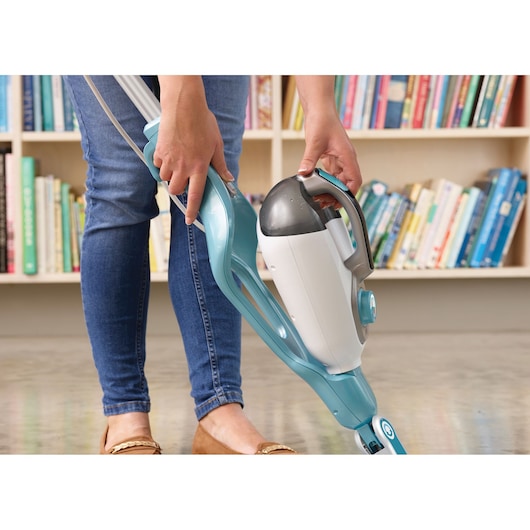 Photo of BLACK+DECKER BHSM1610DSM steam mop in blue and white being used on a hard floor, bookshelf in background.