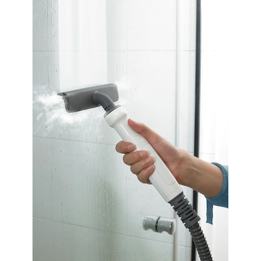 BLACKDECKER BHSM166DSM steam cleaner hand tool cleaning glass shower door, close-up view.