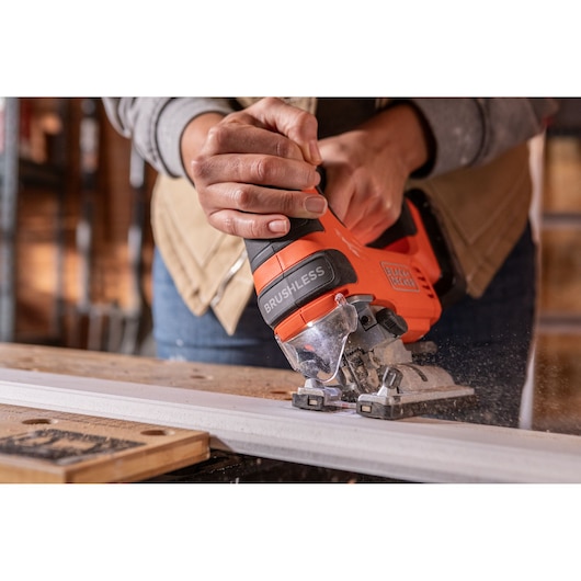 Photo of BLACKDECKER BLCJS78N brushless jigsaw cutting wood, close-up view of hand holding tool.
