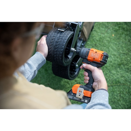 Photo of BLACKDECKER BLIM78N cordless impact wrench used to tighten bolts on a cart wheel outdoors.