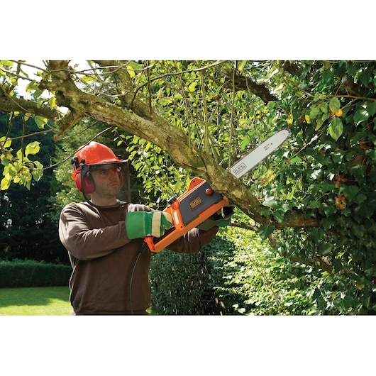 Photo of BLACKDECKER CS1835 chainsaw trimming a tree branch outdoors.