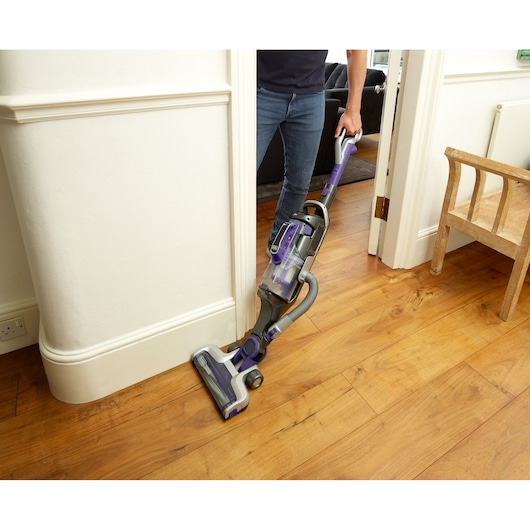 BLACKDECKER CUA525BHP cordless upright vacuum with purple accents cleaning hardwood floor.