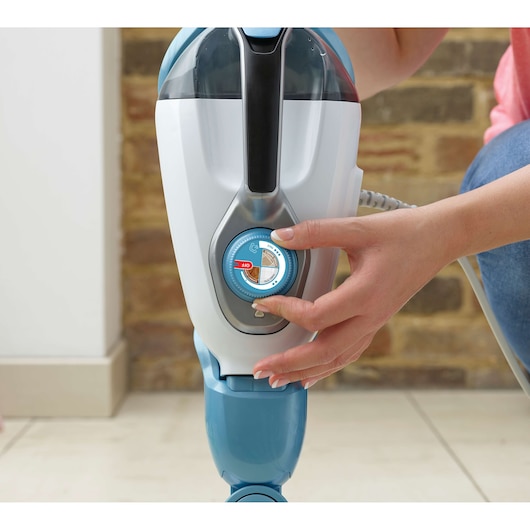 BLACKDECKER FSMH1321 steam mop control dial close-up, with hand adjusting settings, indoors.