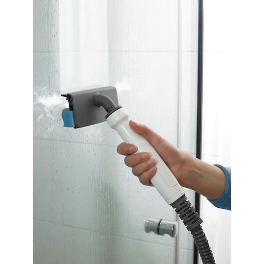 Photo of BLACKDECKER FSMHBA steam cleaner handheld attachment cleaning glass shower door.