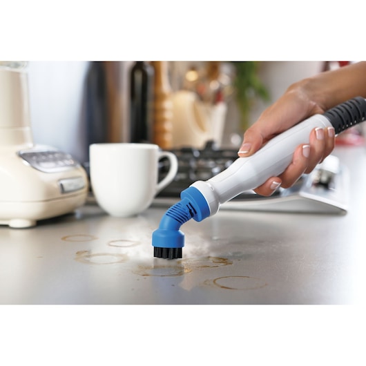 BLACKDECKER FSMHKA steam cleaner brush attachment scrubbing kitchen countertop, close-up view.
