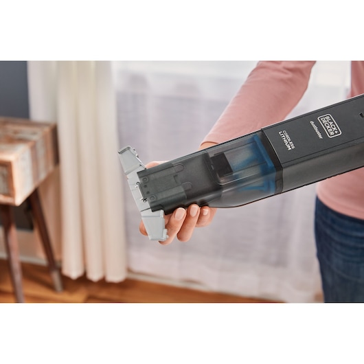 BLACKDECKER HLVC320B11 cordless handheld vacuum cleaner in use, close-up view indoors.