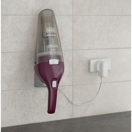 BLACKDECKER NVC115W handheld cordless vacuum mounted on wall, charging via white power adapter.