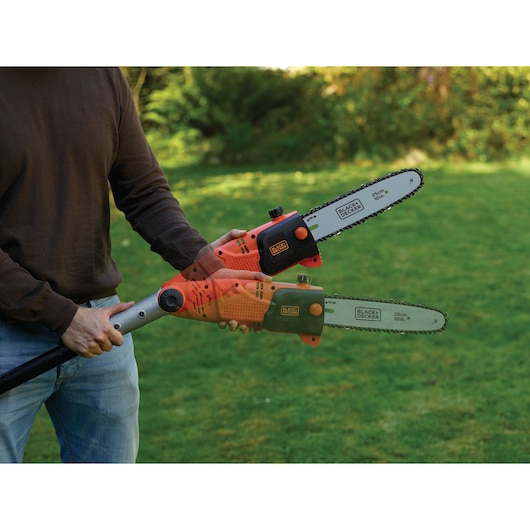 BLACKDECKER PS7525 pole chainsaw in use outdoors, showing cutting angle adjustment on garden lawn.
