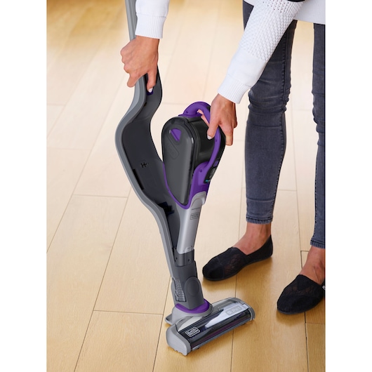 BLACKDECKER SVJ520BFSP cordless stick vacuum in gray and purple, handheld unit being detached, indoor setting